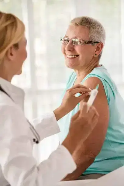Senior woman receiving vaccine at the doctor's office.